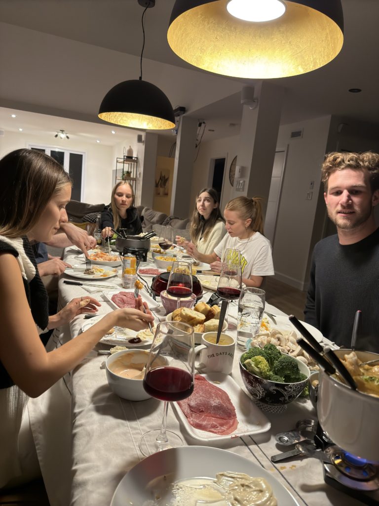 Membres de l'équipe autour d'une table avec des plats de fondue