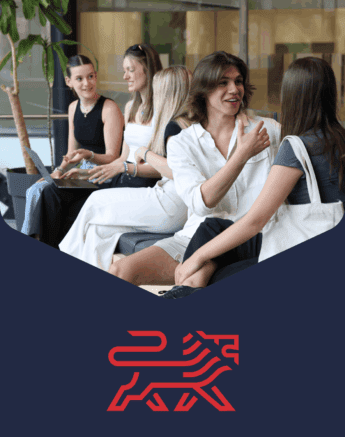 Quatre jeunes adultes sont assis ensemble à l'intérieur, discutant et souriant. Ils sont habillés de façon décontractée et semblent engagés dans une conversation. Au-dessous d'eux se trouve le logo d'un lion rouge stylisé sur fond bleu marine.