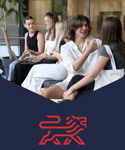 Four young adults sit together indoors, smiling and talking in a relaxed setting. A red stylized lion logo appears below them on a dark blue background.